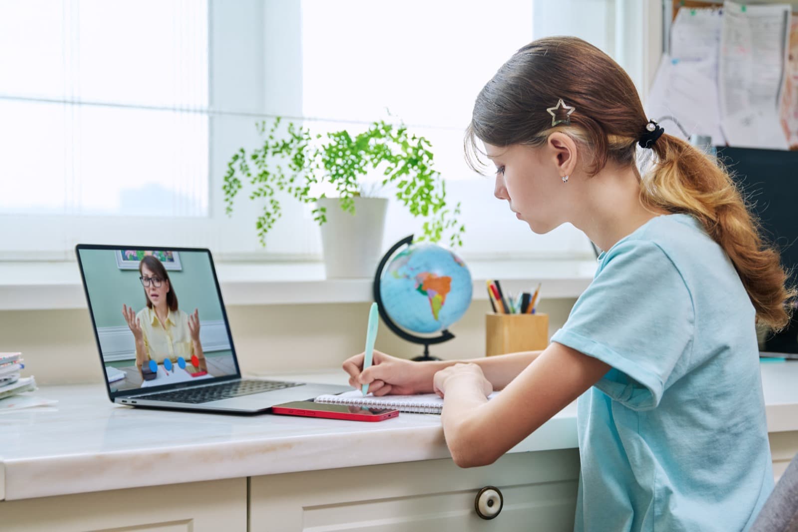 Student with a globe at her laptop