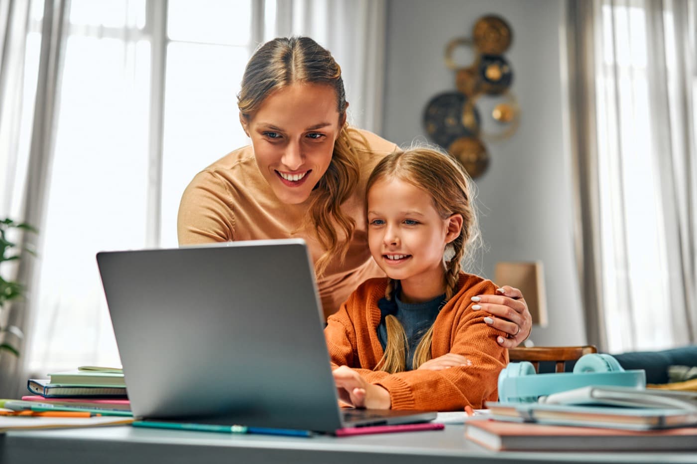 A parent and child looking at tutor profiles together on a laptop