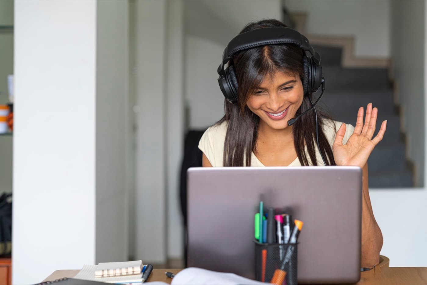 A tutor waving hello at the start of an online lesson